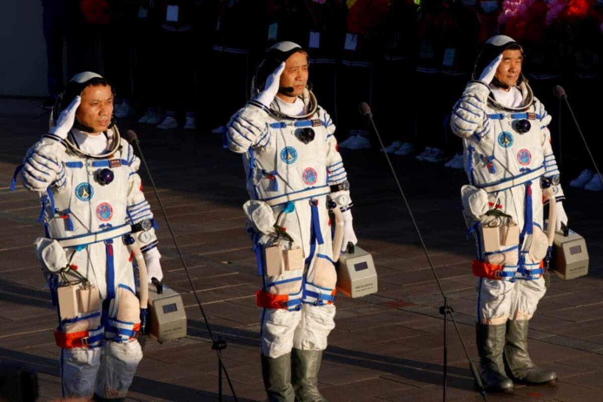 Los astronautas chinos Tang Hongbo, Nie Haisheng y Liu Boming saludan antes del lanzamiento del cohete Long March-2F Y12, que transporta la nave espacial Shenzhou-12 y los tres astronautas, desde el Centro de Lanzamiento de Satélites de Jiuquan para la primera misión tripulada de China para construir su estación espacial, cerca de Jiuquan, provincia de Gansu, China. 17 de junio de 2021. REUTERS/Carlos García Rawlins