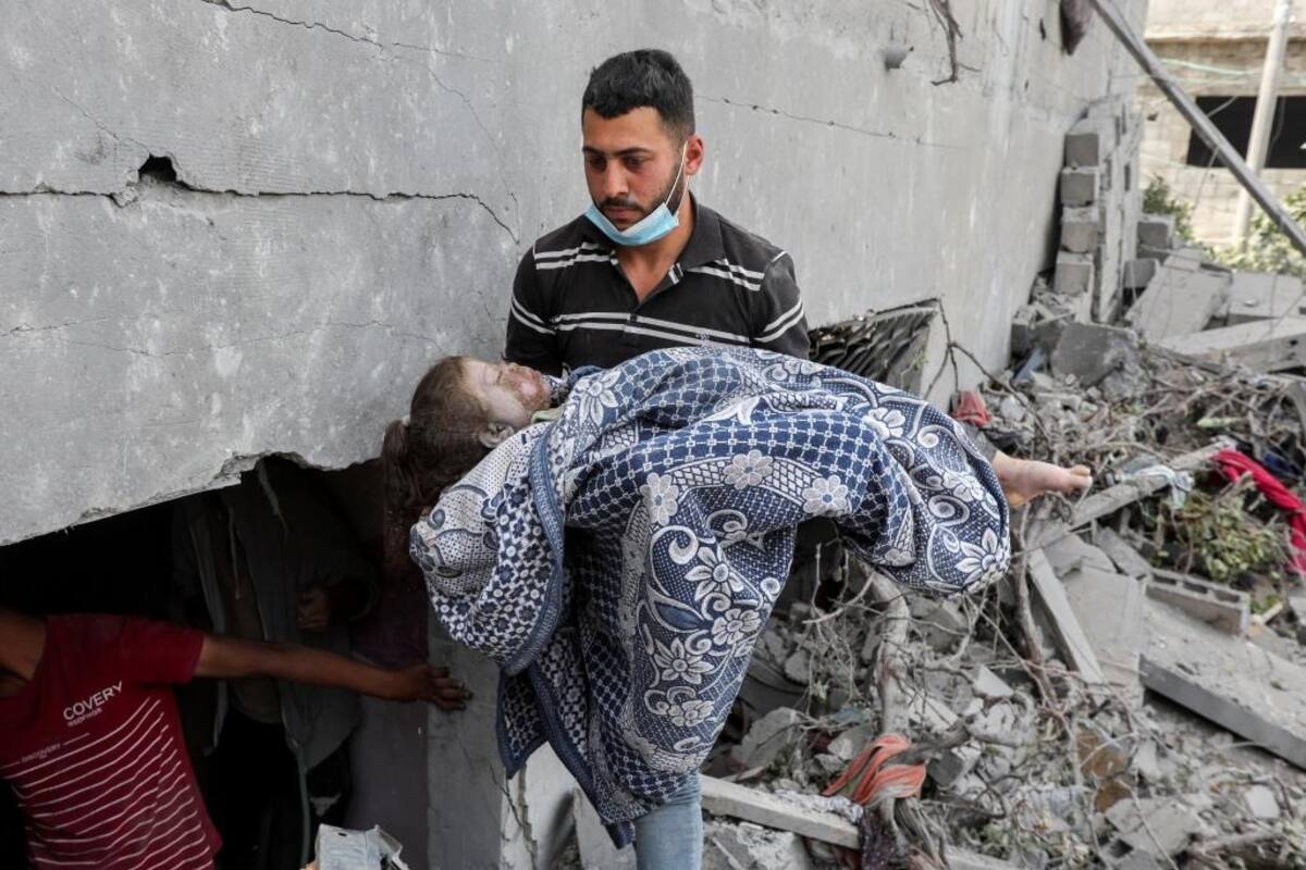 Un hombre rescata el cadáver de una niña palestina de una casa derrumbada tras ataque de Israel. | Crédito: AP
