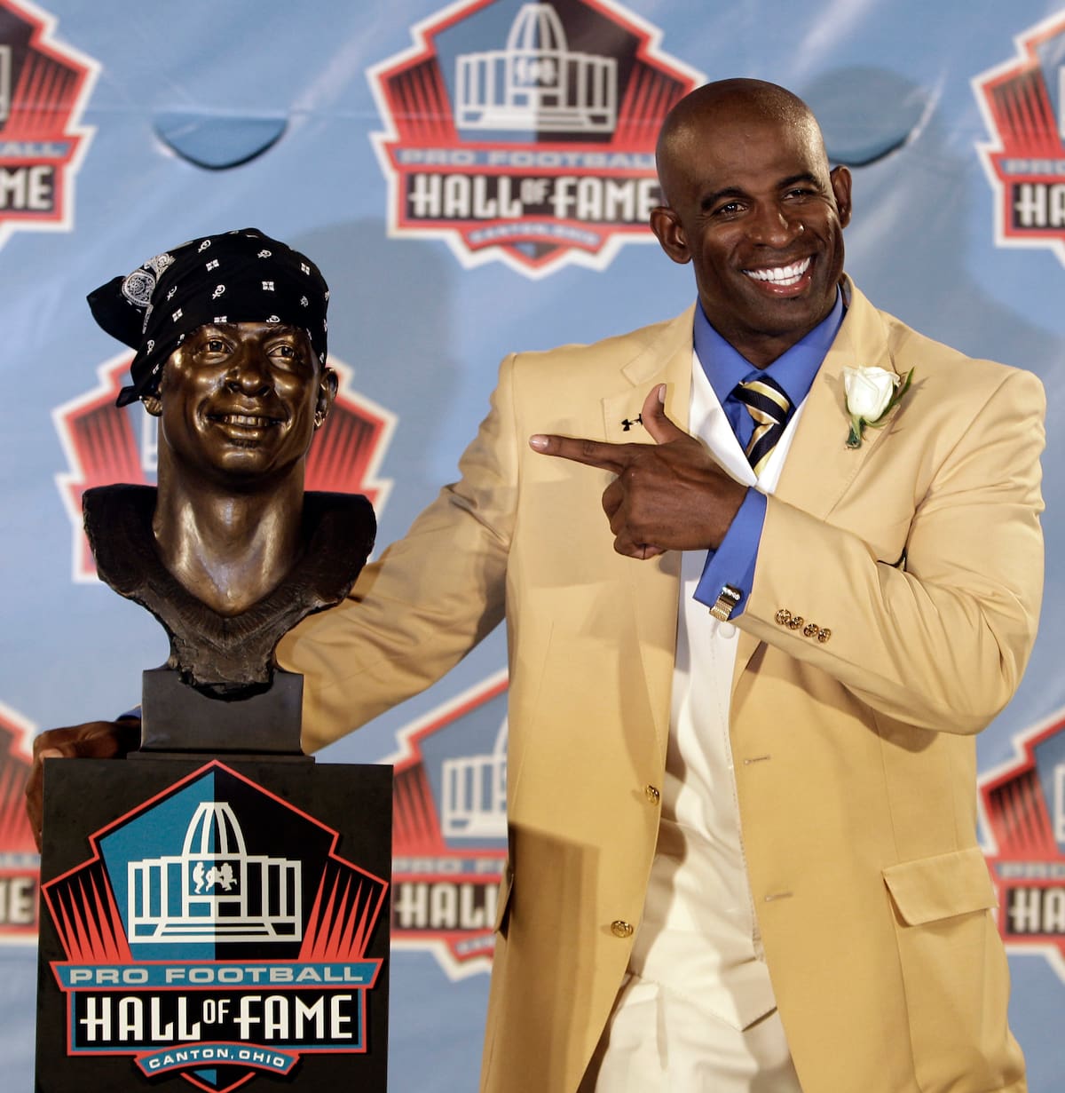 Deion Sanders posa junto a un busto con su imagen durante la ceremonia de ingreso al Salón de la Fama del Futbol Americano Profesional, el sábado 6 de agosto de 2011, en Canton, Ohio. (Foto AP/Tony Dejak)
