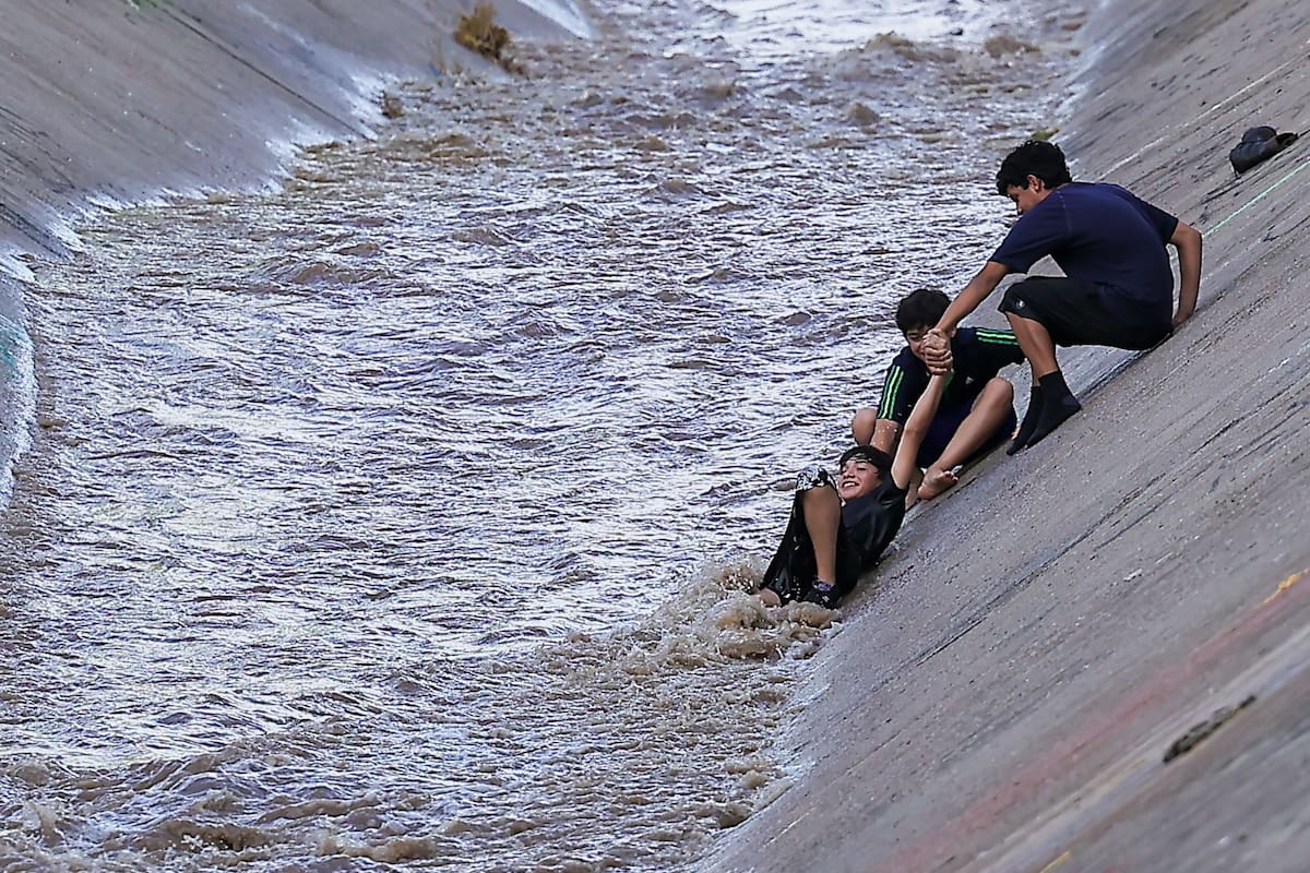 Un agente de la policía estatal, ahuyenta a unos niños que jugaban en el Arroyo 'Las víboras' en la colonia villas del Sur, minutos antes uno de los niños había sido rescatado por sus compañeros de travesuras al caer en las rápidas aguas del arroyo. | Crédito: Eleazar Escobar (GH)