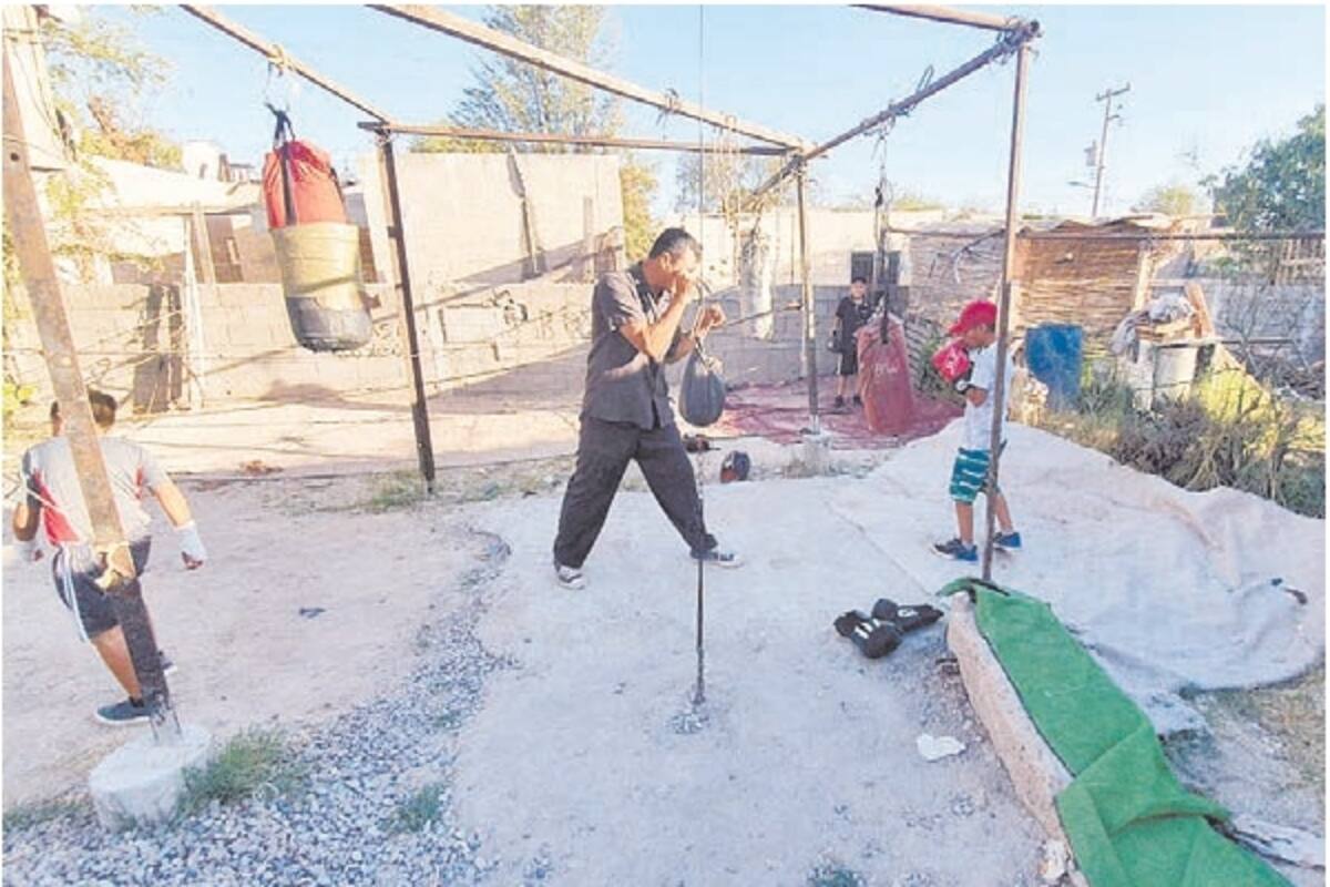 Improvisa gimnasio de box en su casa y entrena a niños