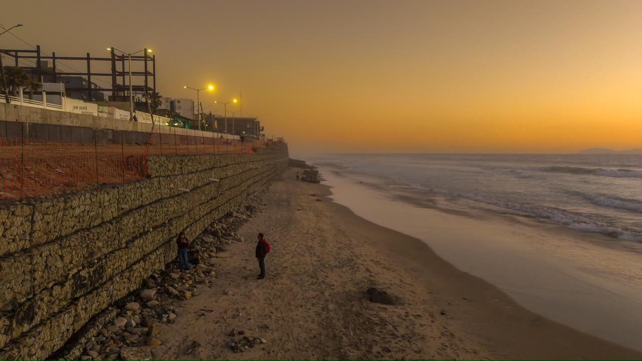 El atardecer de este miércoles regaló una postal de tonos dorados y anaranjados en Playas de Tijuana, donde el sol descendió lentamente sobre el océano Pacífico mientras comenzaban a encenderse las luces del malecón. Foto: Border Zoom