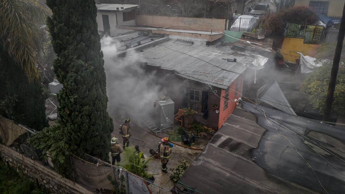 Un hombre que permanecía dentro de una vivienda en Cañón K fue liberado por bomberos y vecinos, luego de abrir un hoyo en la estructura para ponerlo a salvo. Foto: Border Zoom
