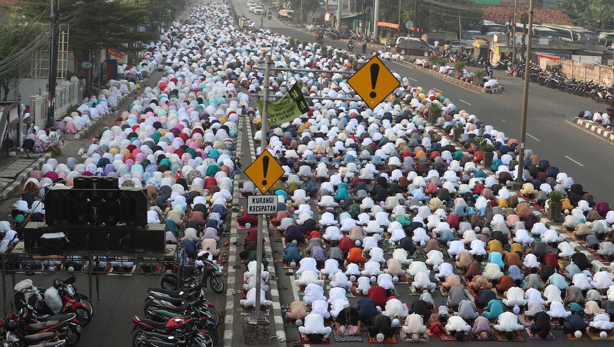 Musulmanes realizan la oración del Eid al-Fitr, que marca el final del mes sagrado del islam, el Ramadán, en una calle en Bekasi, en Java Occidental, Indonesia, el 13 de mayo de 2021. (AP Foto/Achmad Ibrahim)