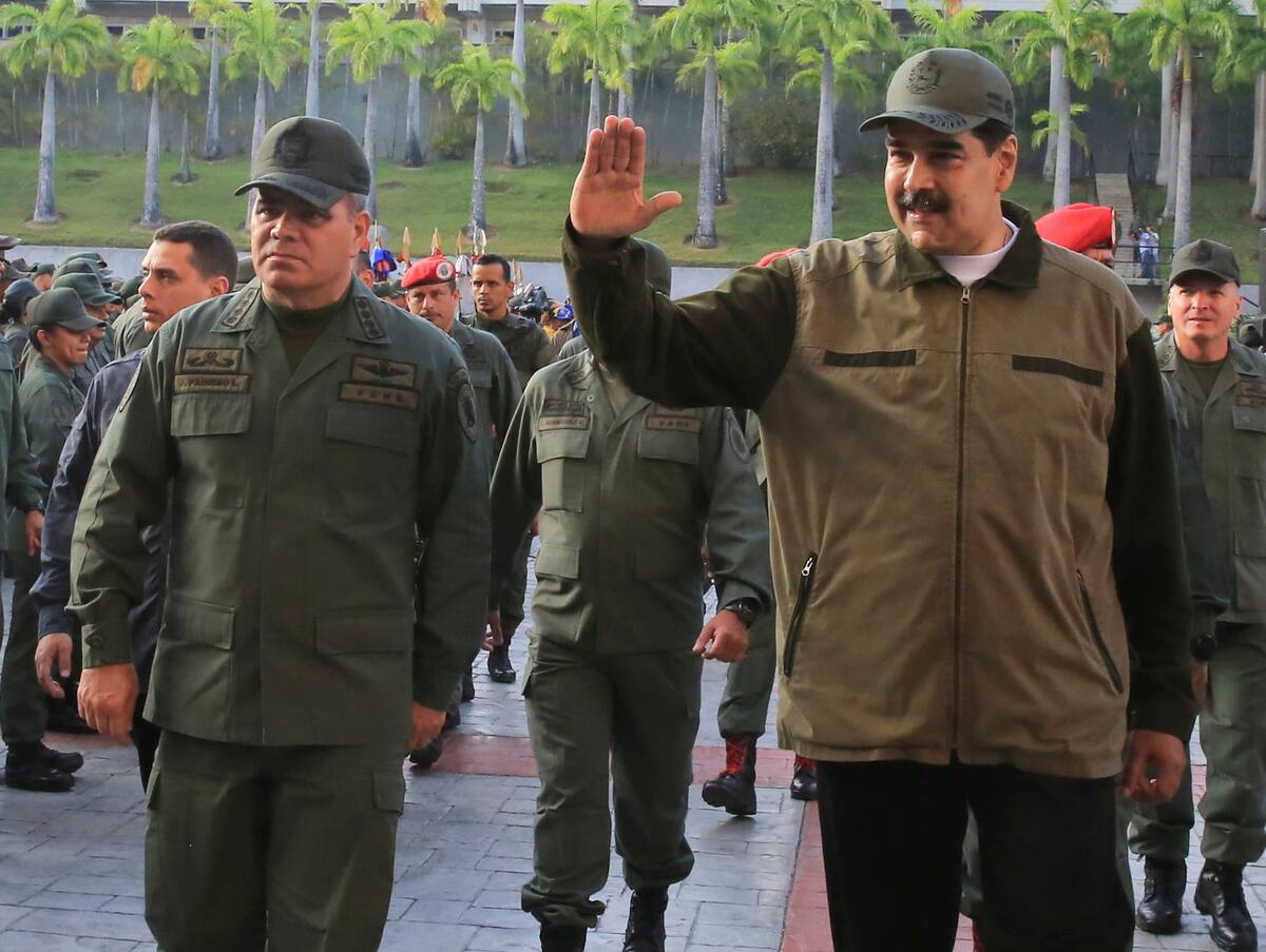 In this photo released by Miraflores Press Office, Venezuela's President Nicolas Maduro, right, accompanied by his Defense Minister Vladimir Padrino Lopez, waves upon his arrival to Fort Tiuna for a meeting with troops, in Caracas, Venezuela, Thursday, May 2, 2019. (Jhonn Zerpa/Miraflores Press Office via AP)