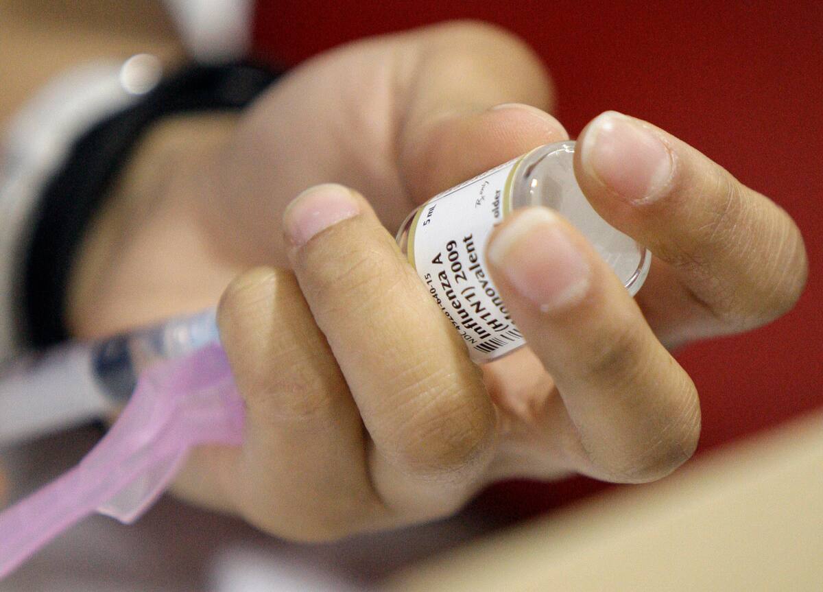 A syringe is used to draw a swine flu vaccine for the next person at a vaccination clinic at Carlin Springs Elementary School in Arlington, Va., Thursday, Jan. 7, 2010. Swine flu-shot drives for all ages are scheduled around the country for what's officially dubbed National Influenza Vaccination Week, in hopes of preventing a possible third wave of the epidemic later this winter. (AP Photo/Alex Brandon)