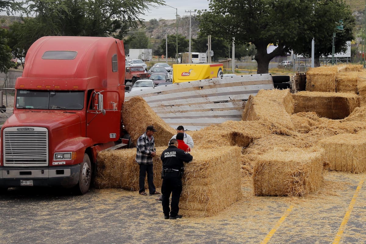¡Se salvan! Vuelca tráiler y cae carga sobre 4 autos