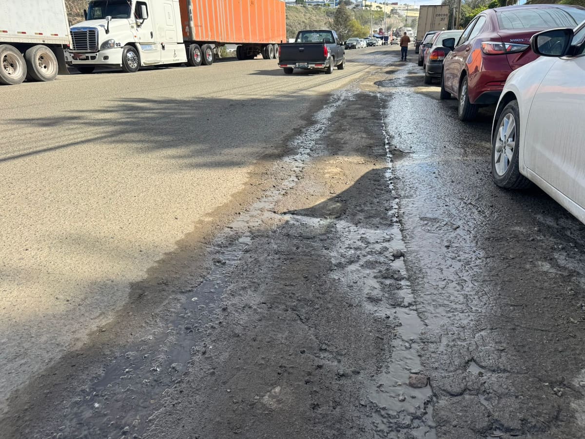 Vecinos y autoridades escolares denunciaron que unidades de carga bloquean la avenida, destruyen la vialidad y obligan a estudiantes a caminar entre tráileres y baches. Foto: Khennia Reyes