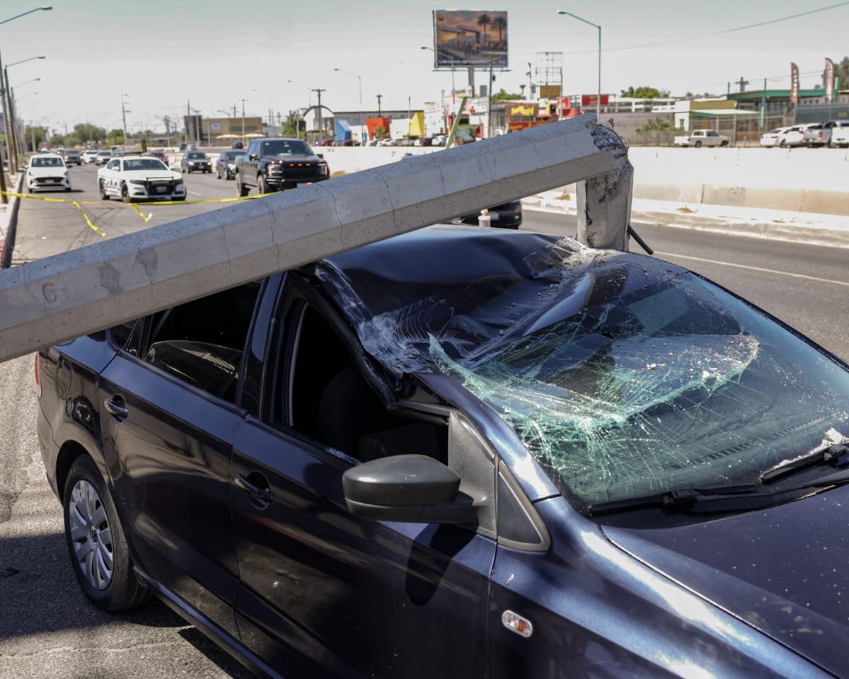 Un poste de concreto cayó sobre un vehículo que circulaba por la calzada Manuel Gómez Morín, en Mexicali, después de que un tractocamión jalara cableado eléctrico y de telecomunicaciones. El incidente dejó personas lesionadas. (Foto: Javier Gallegos)