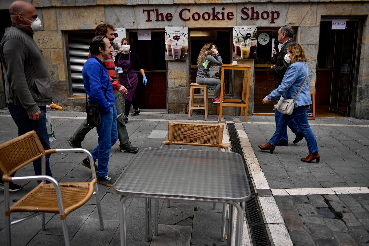 Unas personas caminan por una calle en Pamplona, España, el 11 de mayo de 2020. España sigue flexibilizando las estrictas medidas de confinamiento debido al coronavirus. (AP Foto/Alvaro Barrientos)