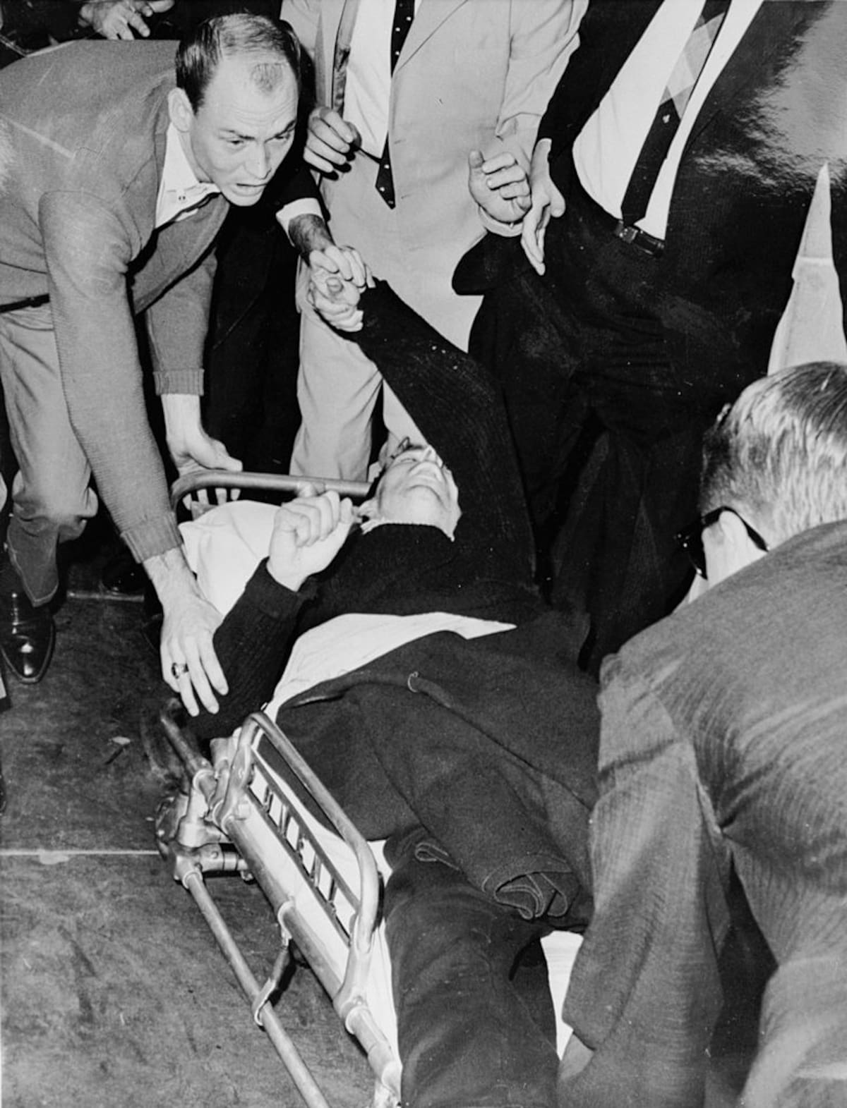 President John F Kennedy's alleged assassin Lee Harvey Oswald is hurried into an ambulance after being shot at Dallas City Prison by night club owner Jack Ruby.    (Photo by Three Lions/Getty Images)