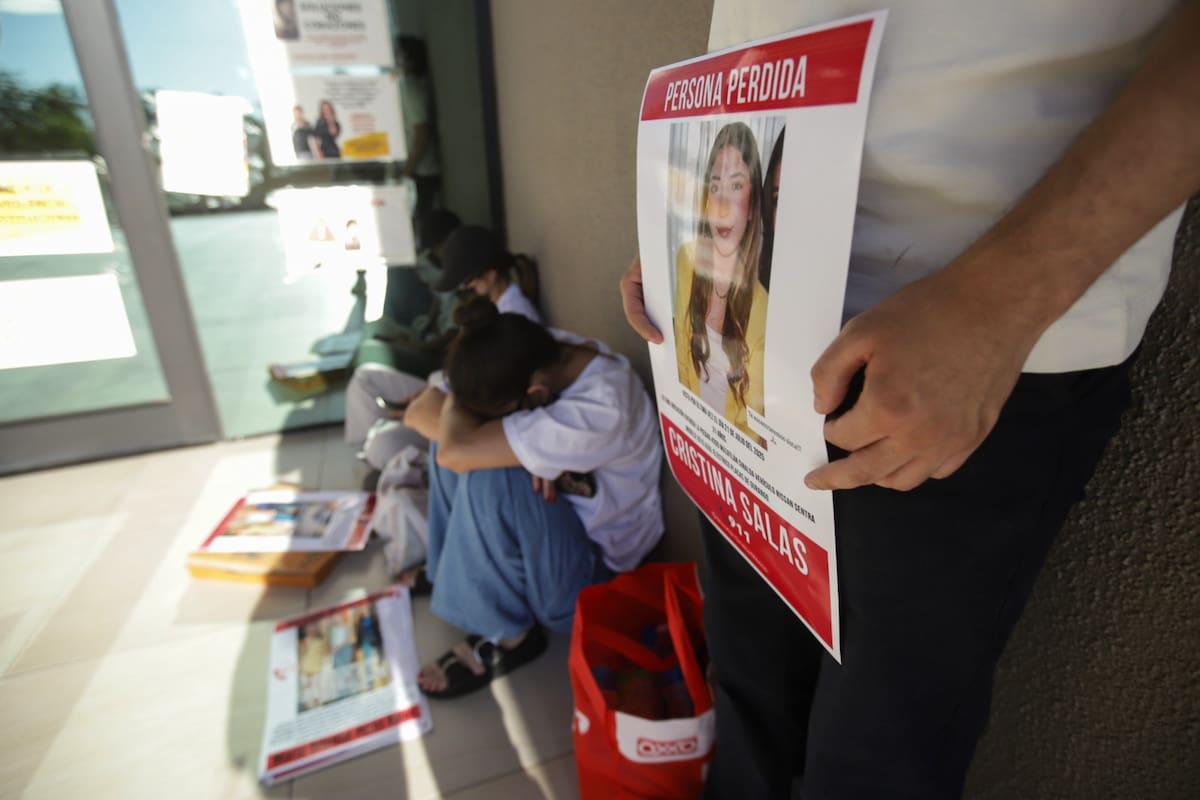 A las afueras de la Fiscalía General del Estado, con el sol de la tarde de frente, dos de sus amigas esperaban a otra quien les trajera cinta adhesiva para colocar los carteles con el rostro de su amiga en las entradas de la institución l Foto: Juan Antonio Hernández
