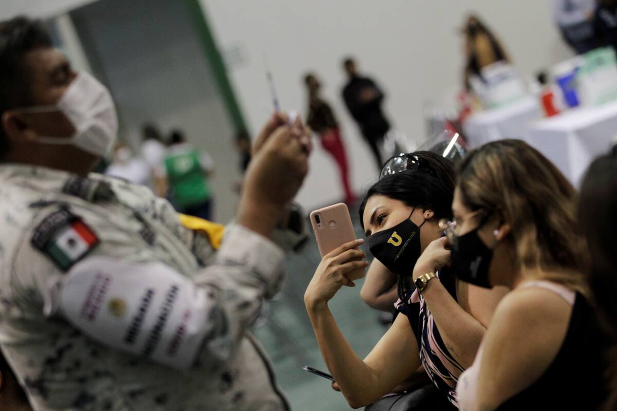 Una trabajadora de una escuela toma una foto después de recibir una dosis de la vacuna china CanSino contra el COVID-19 durante una vacunación masiva contra el coronavirus en la Universidad Autónoma de Nuevo León, en San Nicolás de los Garza, en las afueras de Monterrey, México. 27 de abril de 2021. REUTERS / Daniel Becerril