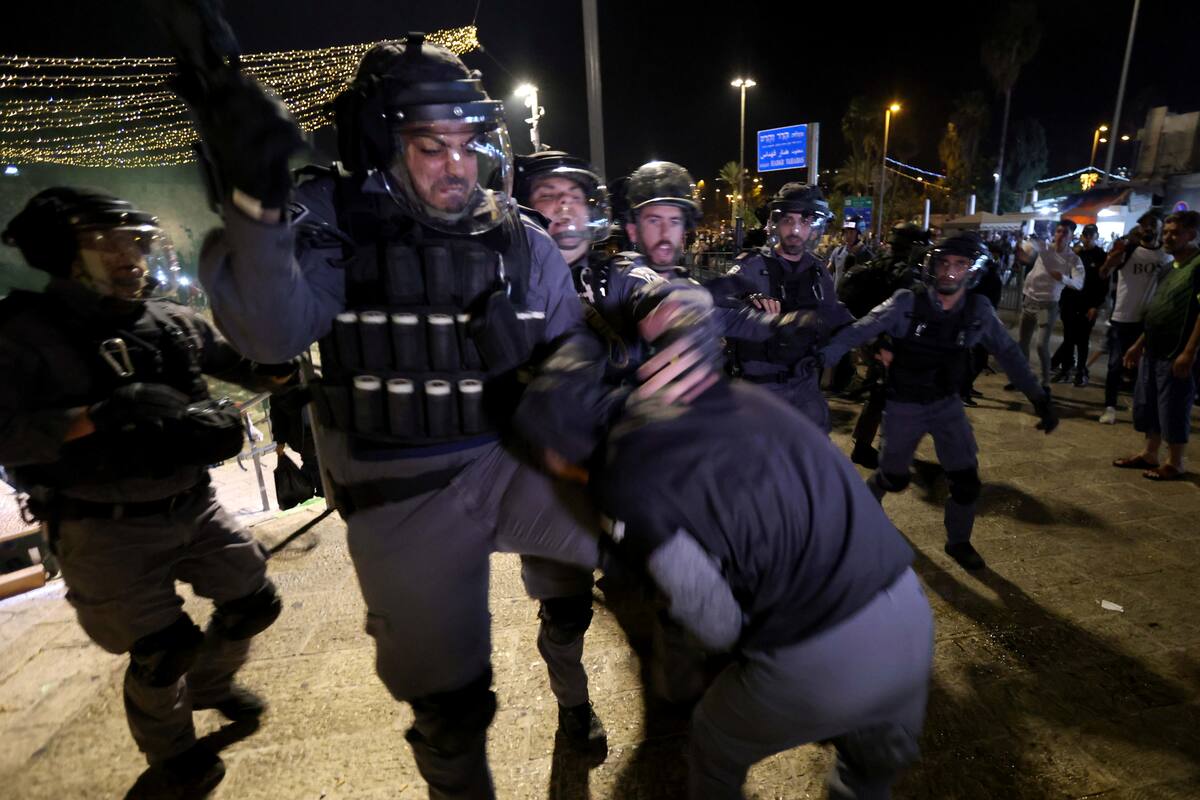 La policía israelí pelea con un palestino durante los enfrentamientos en la Puerta de Damasco durante el Laylat al-Qadr, en el mes sagrado del Ramadán, en la Ciudad Vieja de Jerusalén. 8 de mayo de 2021. REUTERS/Ronen Zvulun