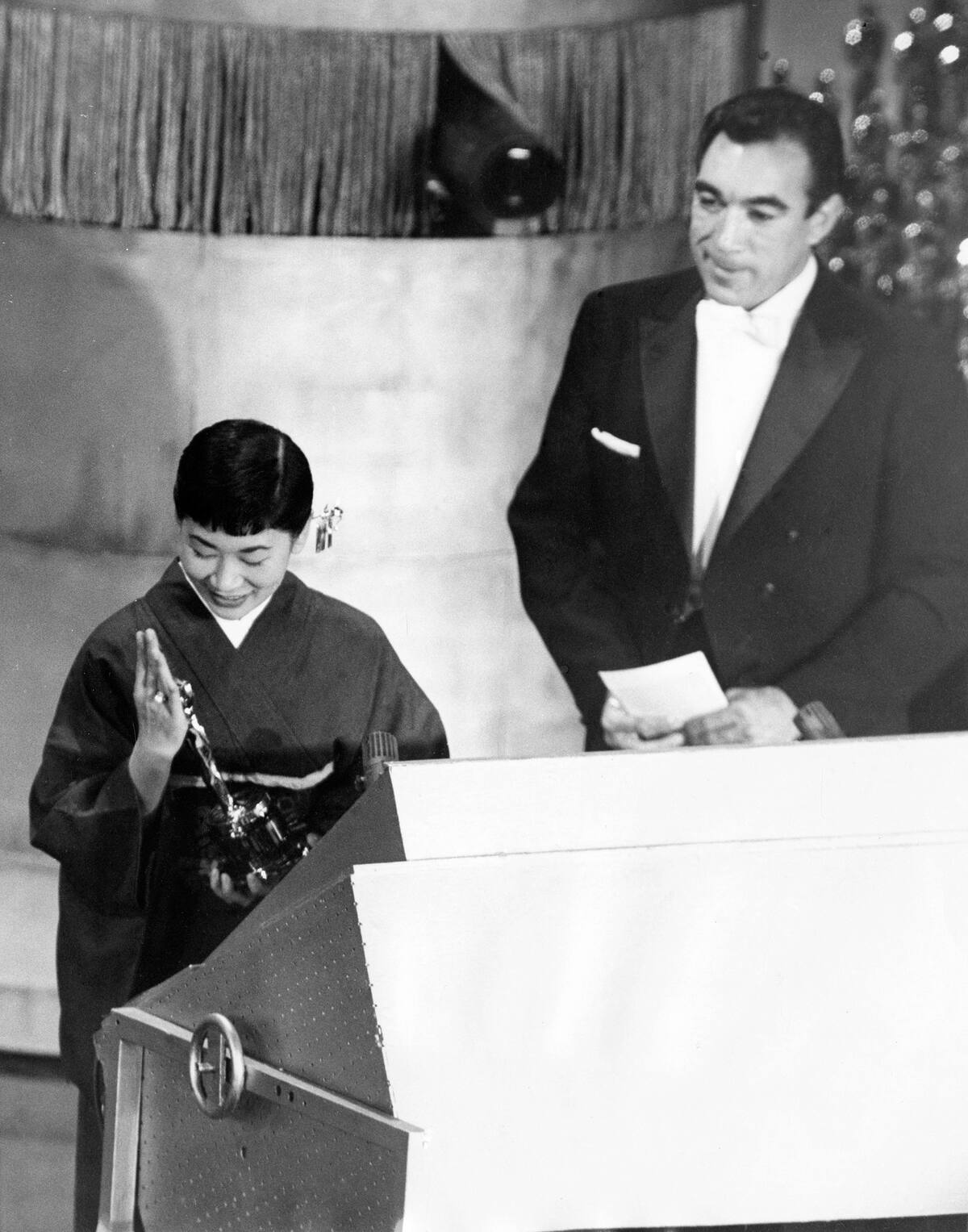 ARCHIVO – La actriz japonesa Miyoshi Umeki recibe el Premio de la Academia a mejor actriz de reparto por su papel en "Sayonara", mientras el presentador Anthony Quinn la mira en los Premios de la Academia en Los Angeles el 26 de marzo de 1958. Umeki es la primera persona de Japón en ganar un Oscar. (Foto AP)