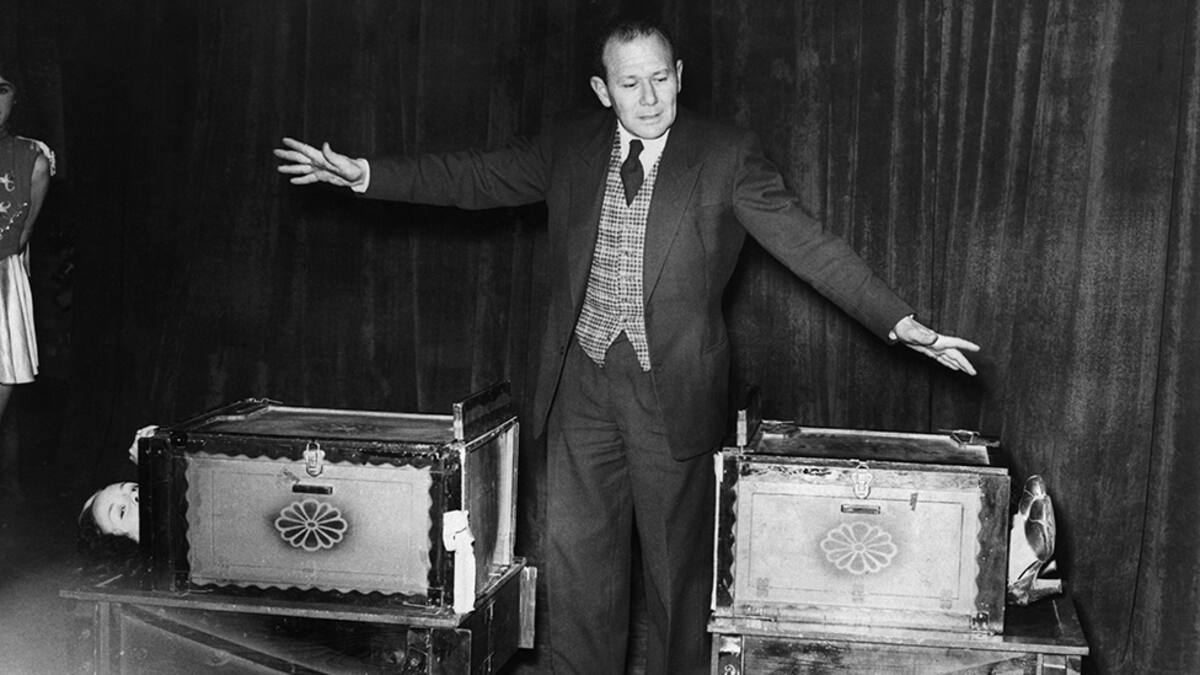 (Original Caption) 1951-Magician after successful completion of sawing a woman in two act. Robert Harbin. BPA2# 2912
