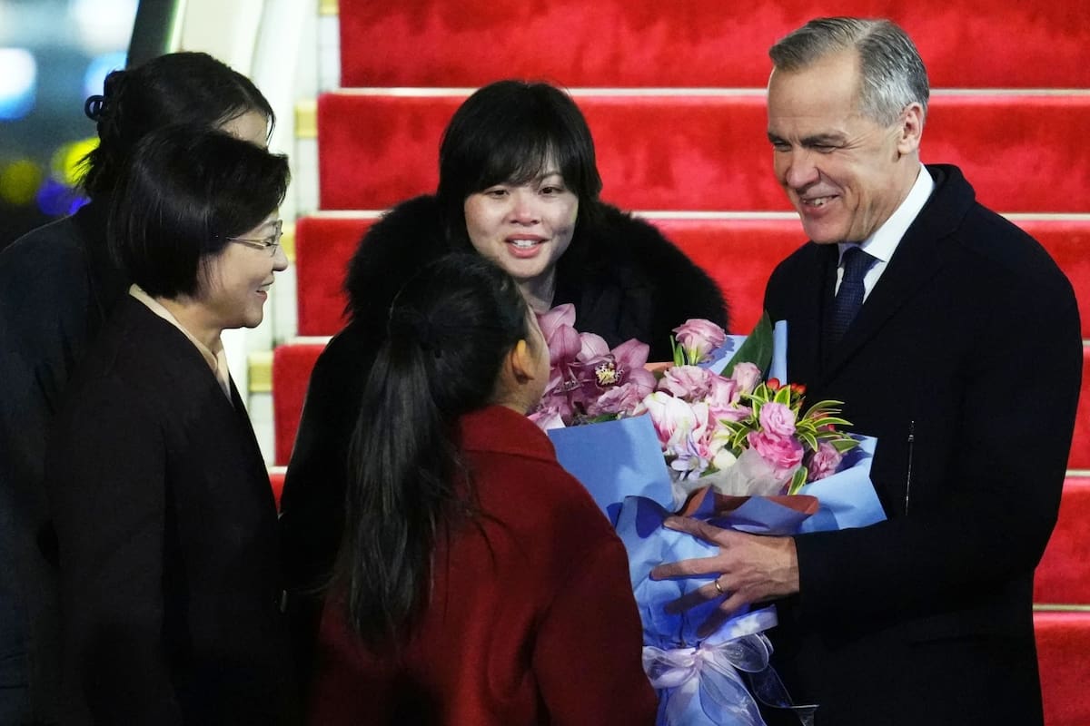 El primer ministro de Canadá, Mark Carney, recibe flores de Lu You Ci, de 11 años, durante su ceremonia de bienvenida tras su desembarco en Pekin, China, el miércoles 14 de enero de 2026. | Crédito: The Canadian Press/Sean Kilpatrick, via AP