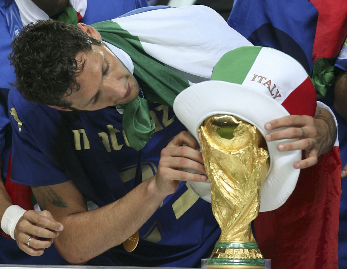 BERLIN(ALEMANIA), 09/07/06.- El jugador de la selección italiana Marco Materazzi coloca un sombrero con los colores de la bandera de Italia al trofeo de la Copa del Mundo tras imponerse a Francia en la final del Mundial disputada hoy en el estadio Olímpico de Berlín. EFE/Marcelo Sayao