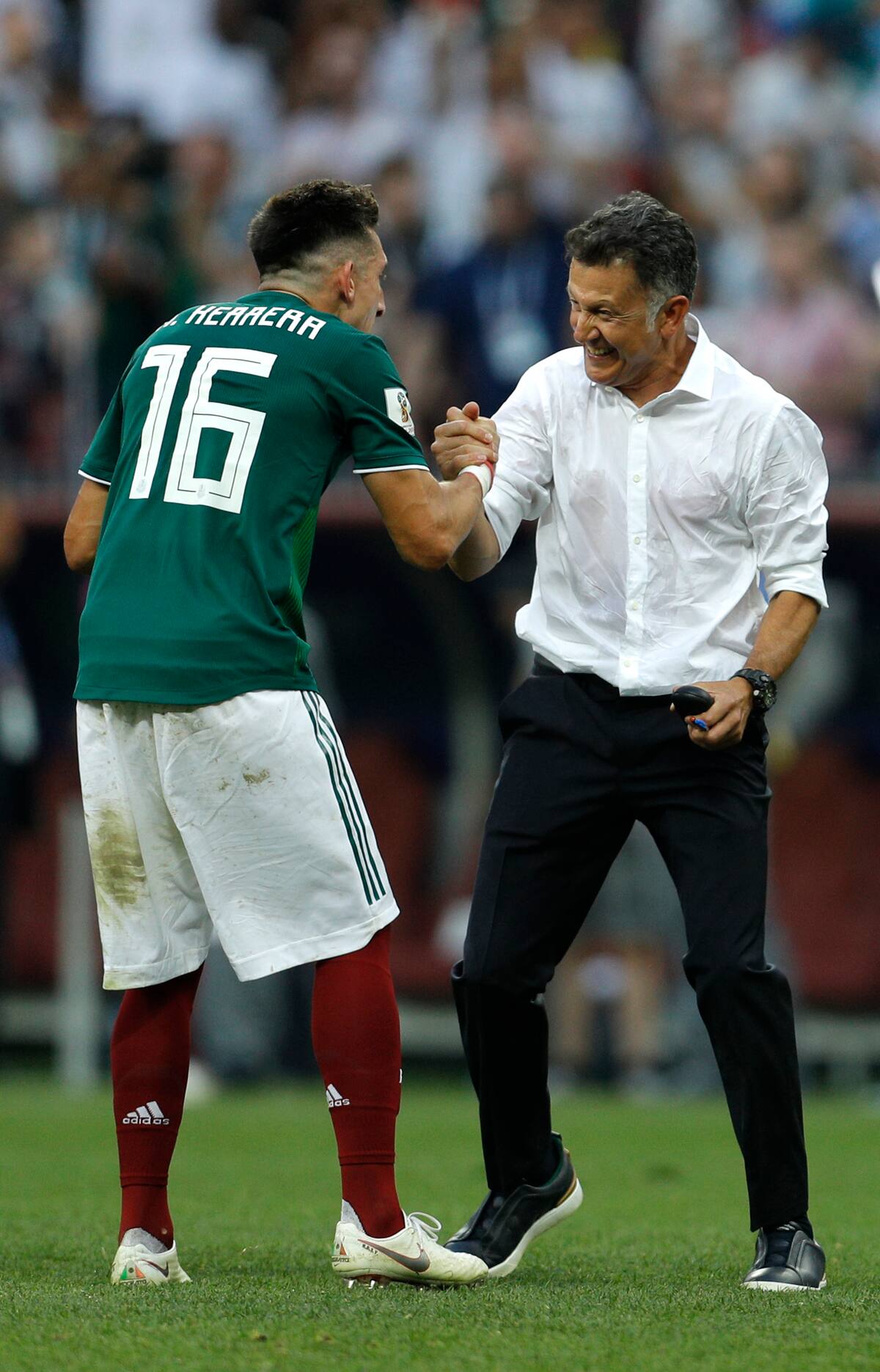 Juan Carlos Osorio festeja con Héctor Herrera tras vencer a Alemania en el Mundial 2018.