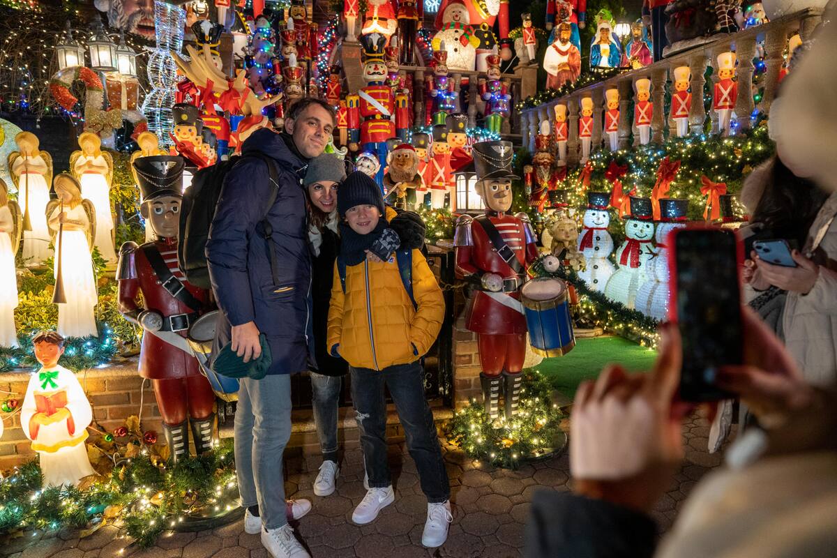 Personas visitan decoraciones navideñas puestas en las entradas de casas, el 8 de diciembre de 2022 en el barrio residencial de Dyker Heights, al sur de Brooklyn, Nueva York (EE. UU). EFE/Ángel Colmenares