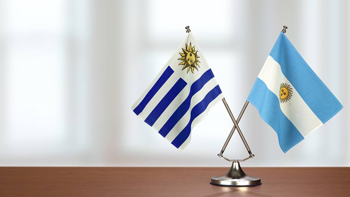 Two crossed national flags on wooden table