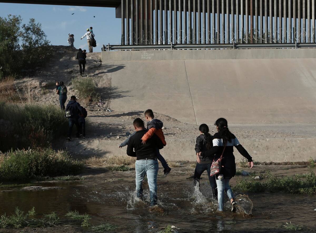 Familias de migrantes cruzan el Río Bravo para ingresar ilegalmente a Estados Unidos, donde se entregarán a las autoridades y solicitarán asilo, cerca de El Paso, Texas.