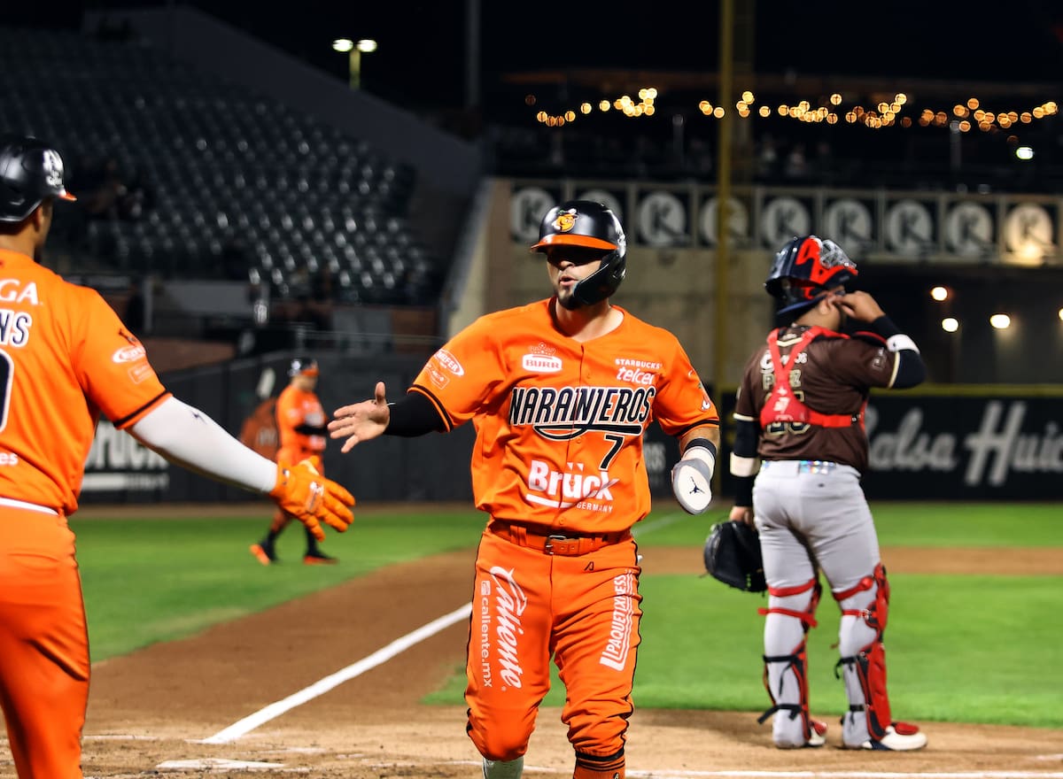 Jasson Atondo es felicitado en el plato tras anotar una carrera.