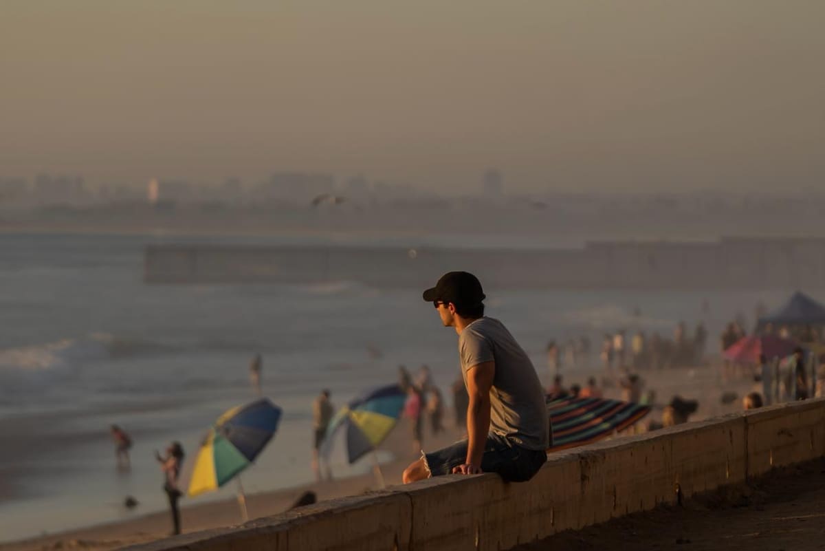El atardecer de este martes en Playas de Tijuana reunió a decenas de personas frente al mar tras una jornada de altas temperaturas en la ciudad. Foto: BorderZoom