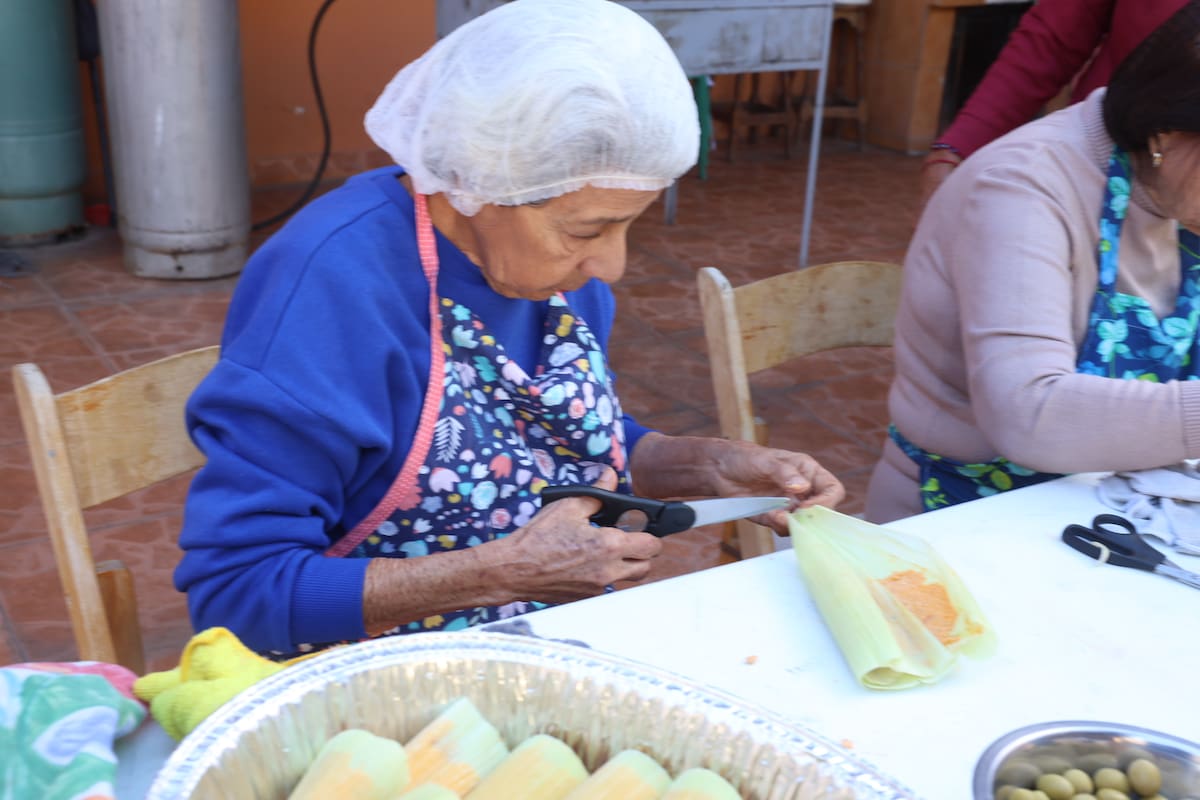 Hilda María Curiel recorta una parte de las hojas de elote para que los tamales queden perfectos.