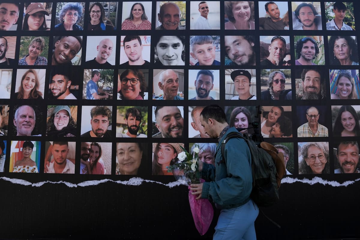 Un hombre pasa por delante de un cartel que pide el regreso de los alrededor de 240 rehenes capturados por Hamás el 7 de octubre en Israel, en Jerusalén, el 24 de noviembre de 2023. (AP Foto/Mahmoud Illean)