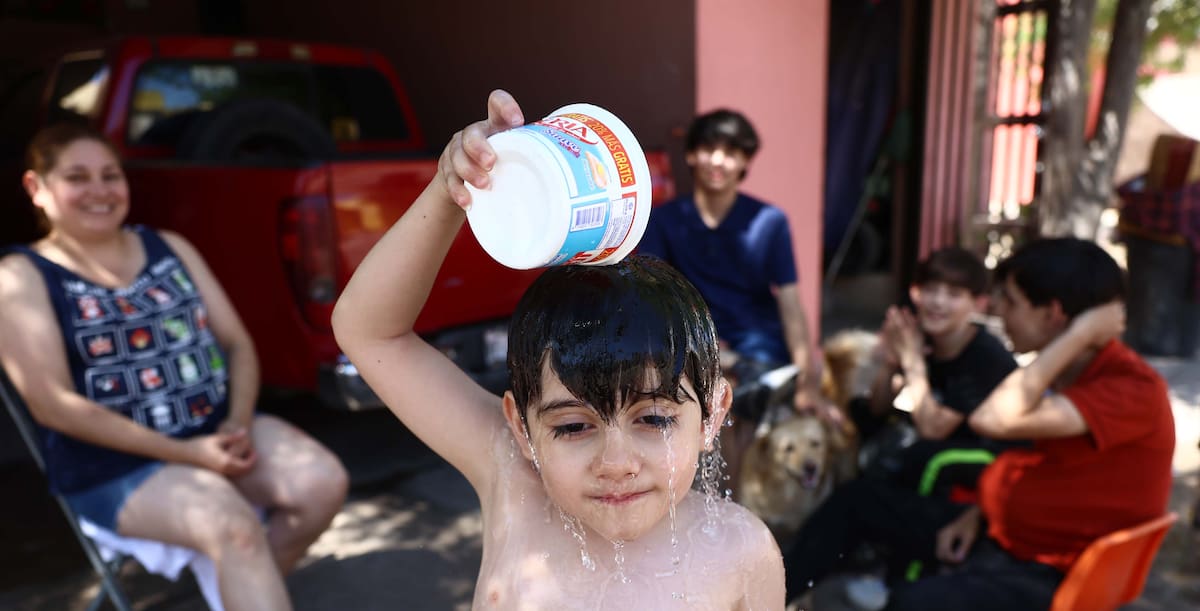 El pequeño Eduardo David, de 4 años, se baña para mitigar el calor, en la colonia Haciendas del Sur. FOTO: TEODORO BORBÓN