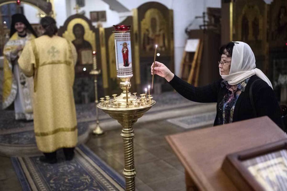 Sacerdote de la Iglesia ortodoxa rusa bendice a su feligreses a manguerazos