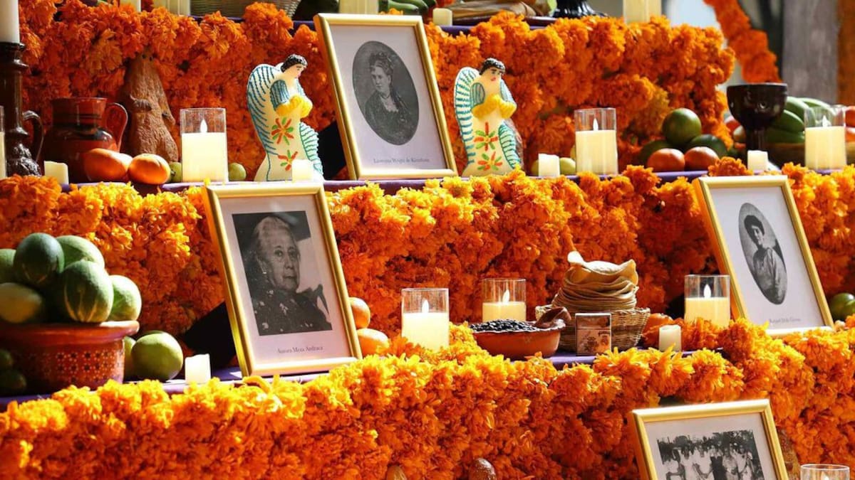 Altar de cinco niveles con flores de cempasúchil y fotografías de pioneras en Palacio Nacional.