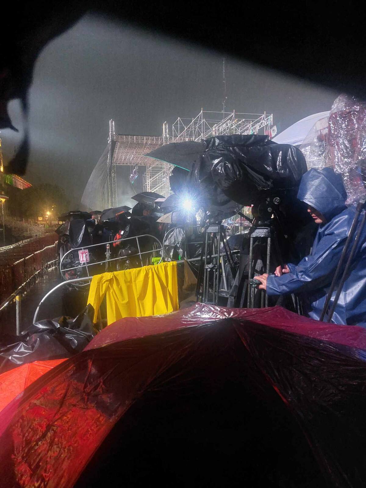 Trabajadores de la prensa se cubrieron de la lluvia durante la espera para el Grito.  Foto: Shaila Rosagel.