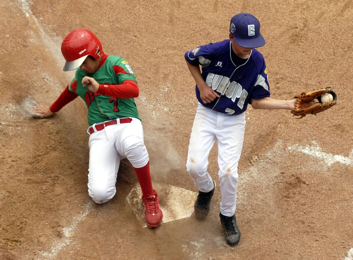 Reynosa, Mexico's Luis Trevino scores on a wild pitch as Ramstein AFB, Germany pitcher Chris Holba covers the plate in the fourth inning of Little League World Series baseball pool play in South Williamsport, Pa., Monday, Aug. 24, 2009. Reynosa, Mexico won the game 13-0.(AP Photo/Tom E. Puskar)