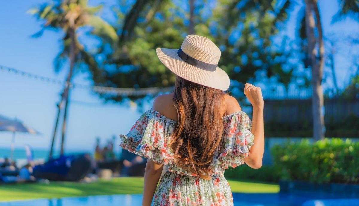 Una turista observa un entorno tropical durante sus vacaciones, reflejando las nuevas tendencias de viaje que priorizan la sustentabilidad y el descanso fuera de la temporada alta. | Magnific