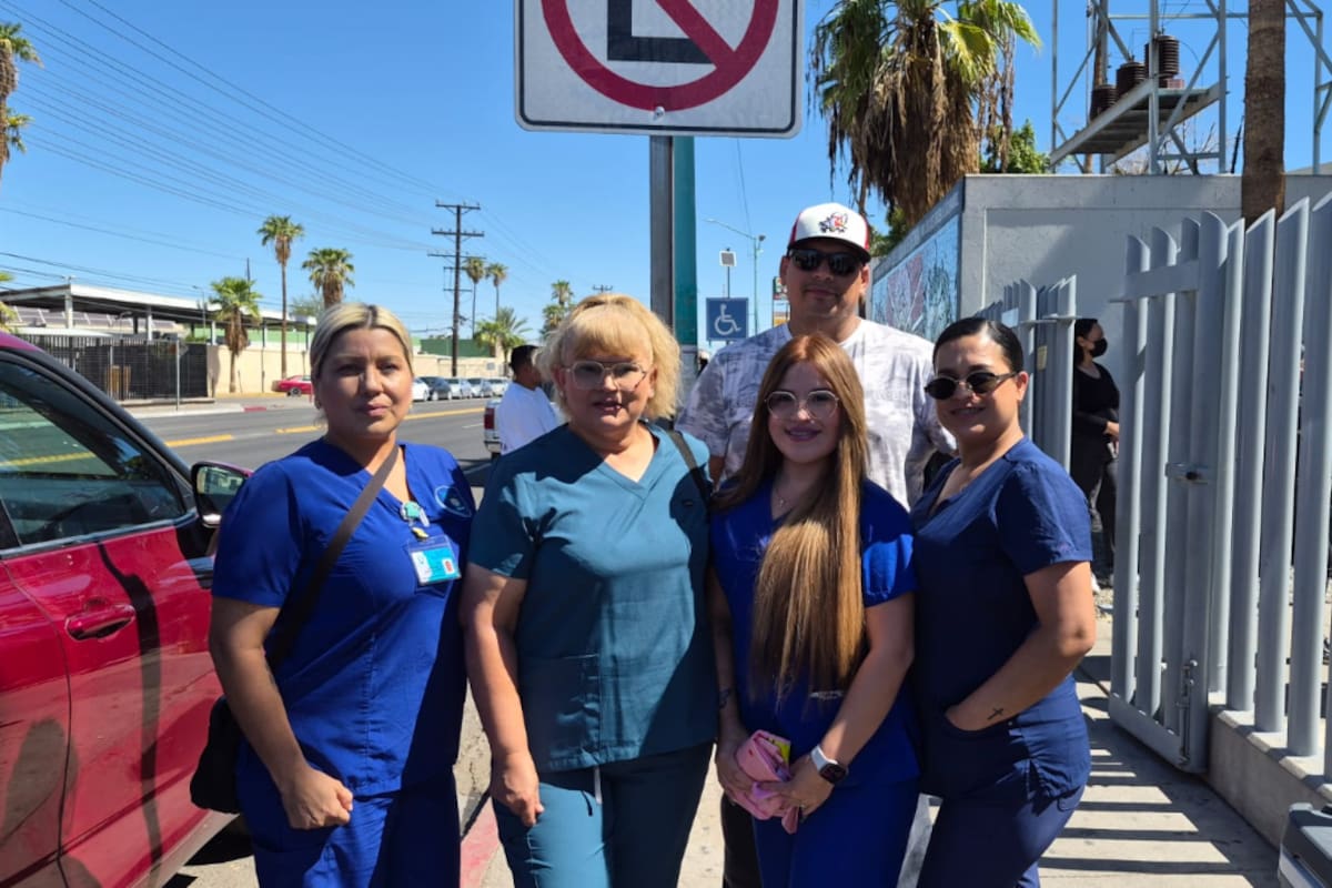 Enfermeras llevan comida y agua a personas que esperan en el Hospital General de Mexicali