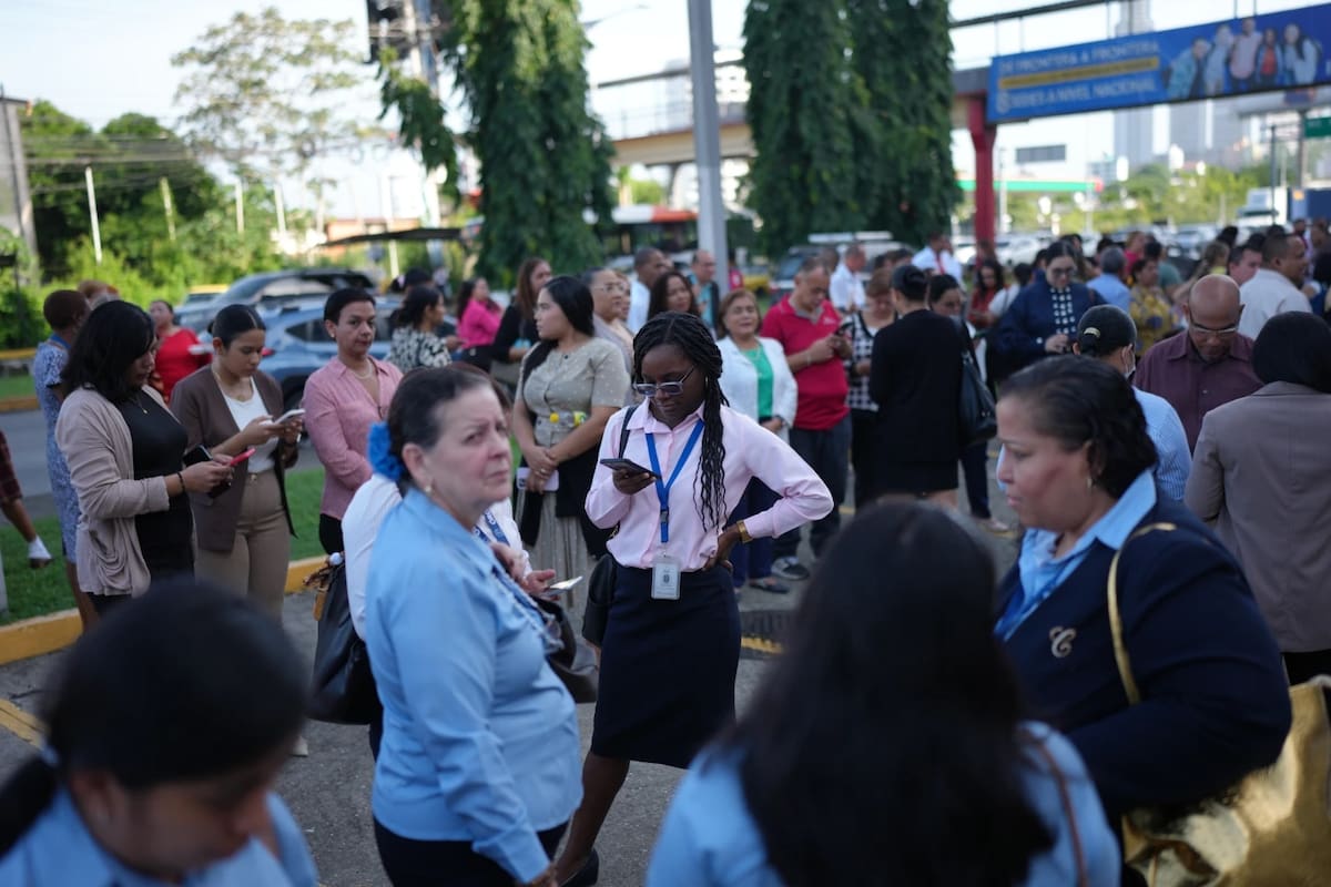 Funcionarios públicos permanecen de pie frente a sus oficinas en la Ciudad de Panamá, el lunes 10 de agosto de 2026, tras sentir un terremoto con epicentro en la vecina Colombia. | Crédito: AP/Matias Delacroix