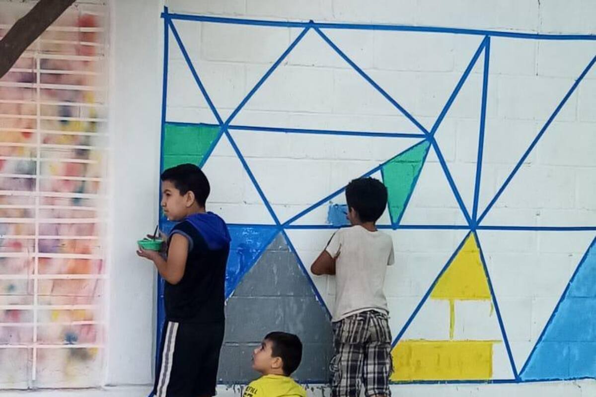 Niños llenan de color paredes de su colonia