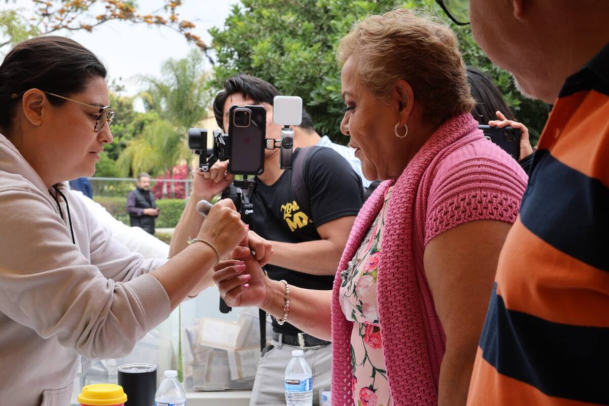 Maricarmen Flores al momento de recibir la tinta indeleble en el dedo después de votar.