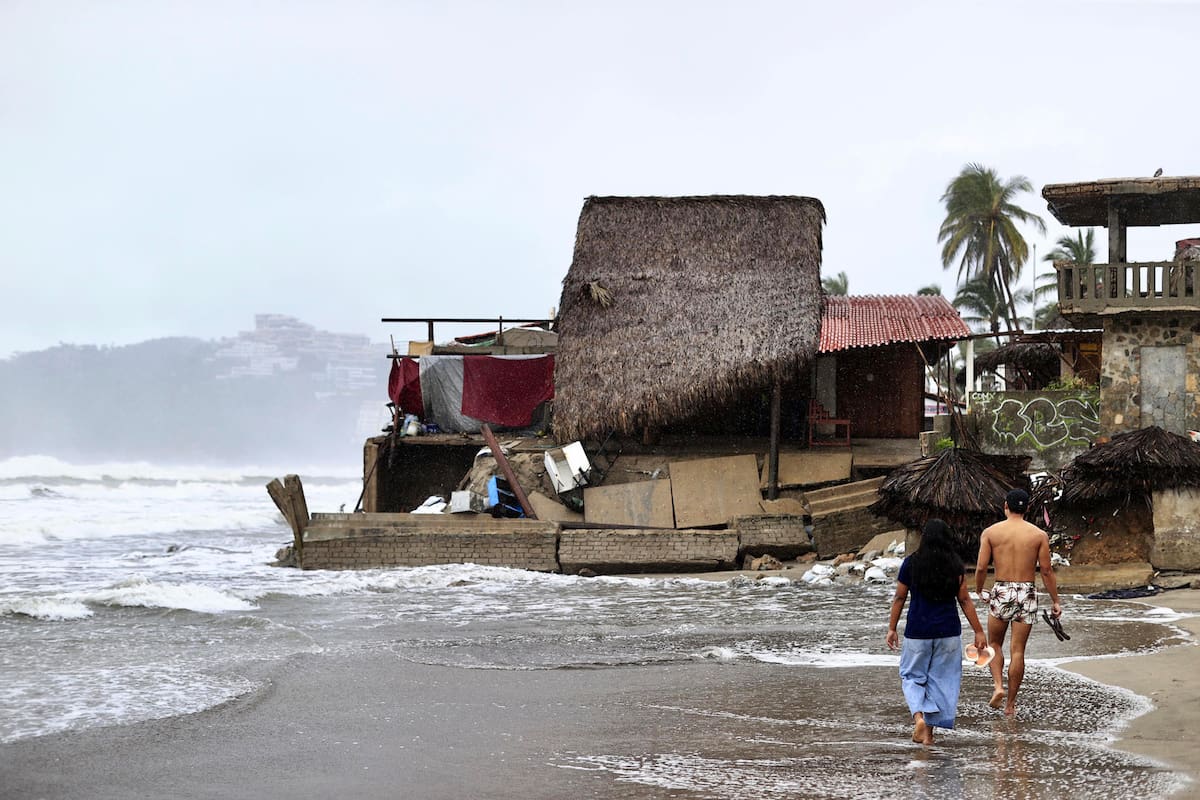 MEX5402. ACAPULCO (MÉXICO), 14/06/2025.- Personas observan los estragos causados por el fuerte oleaje e intensas lluvias, este sábado en Acapulco (México). La tormenta tropical Dalila ha dejado daños en la infraestructura del puerto mexicano de Acapulco, estado de Guerrero (sur), como restaurantes y techos de edificios colapsados, árboles caídos, calles inundadas y deslaves en avenidas principales, tras su avance con intensas lluvias por el Pacífico mexicano. | Crédito: EFE/ David Guzmán