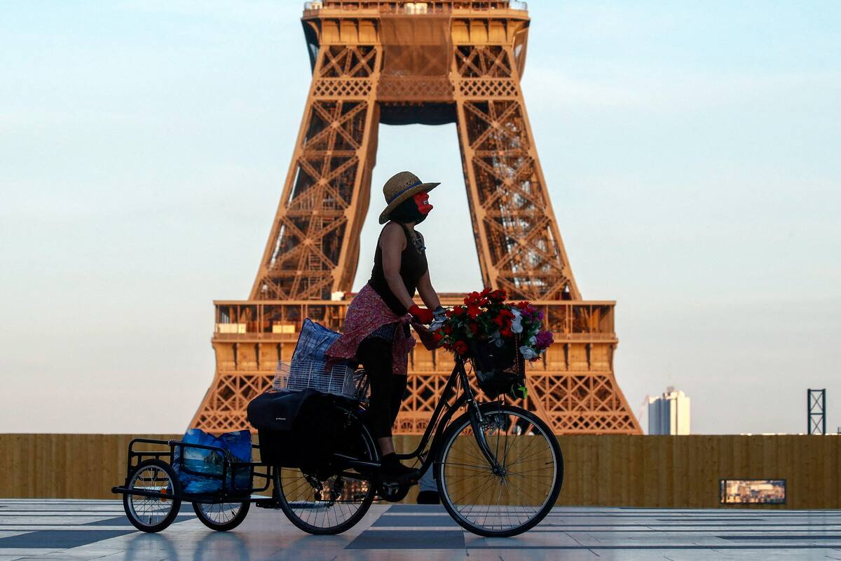 Imagen de archivo de una mujer montando una bicicleta cerca de la torre Eiffel, en la plaza del Trocadero de París. | Crédito: REUTERS/Gonzalo Fuentes/Archivo