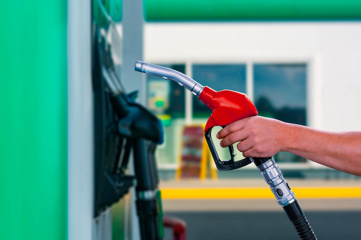 Man holds a refueling gun in his hand for refueling cars. Gas station with diesel and gasoline fuel close-up