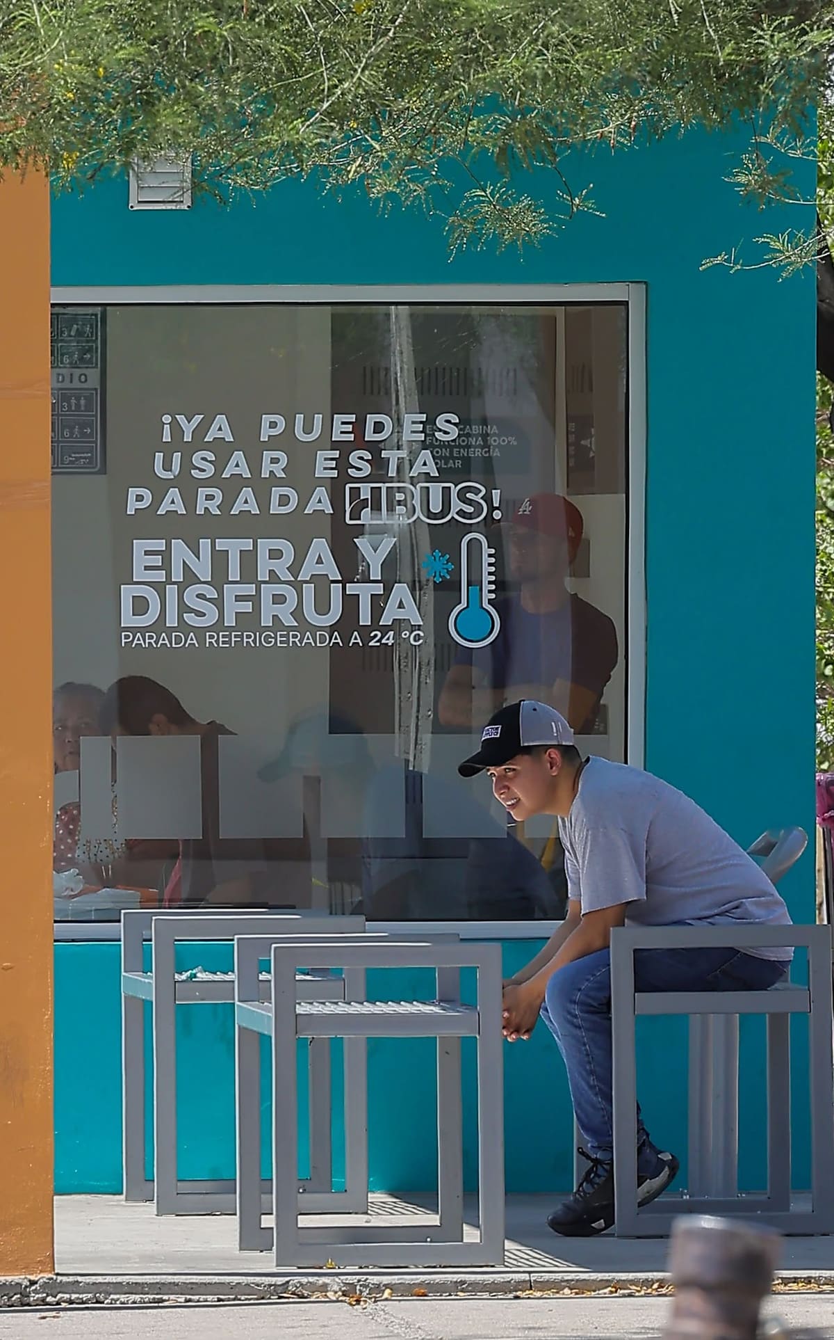 Un hombre espera su autobús por fuera de la parada que promete una temperatura confortable, prefiere pasar el calor de media tarde, ante el riesgo que el camionero no se detenga si alguien no le hace la parada, esto en el parabus de la plaza Leona Vicario. / Imagen por Eleazar Escobar.