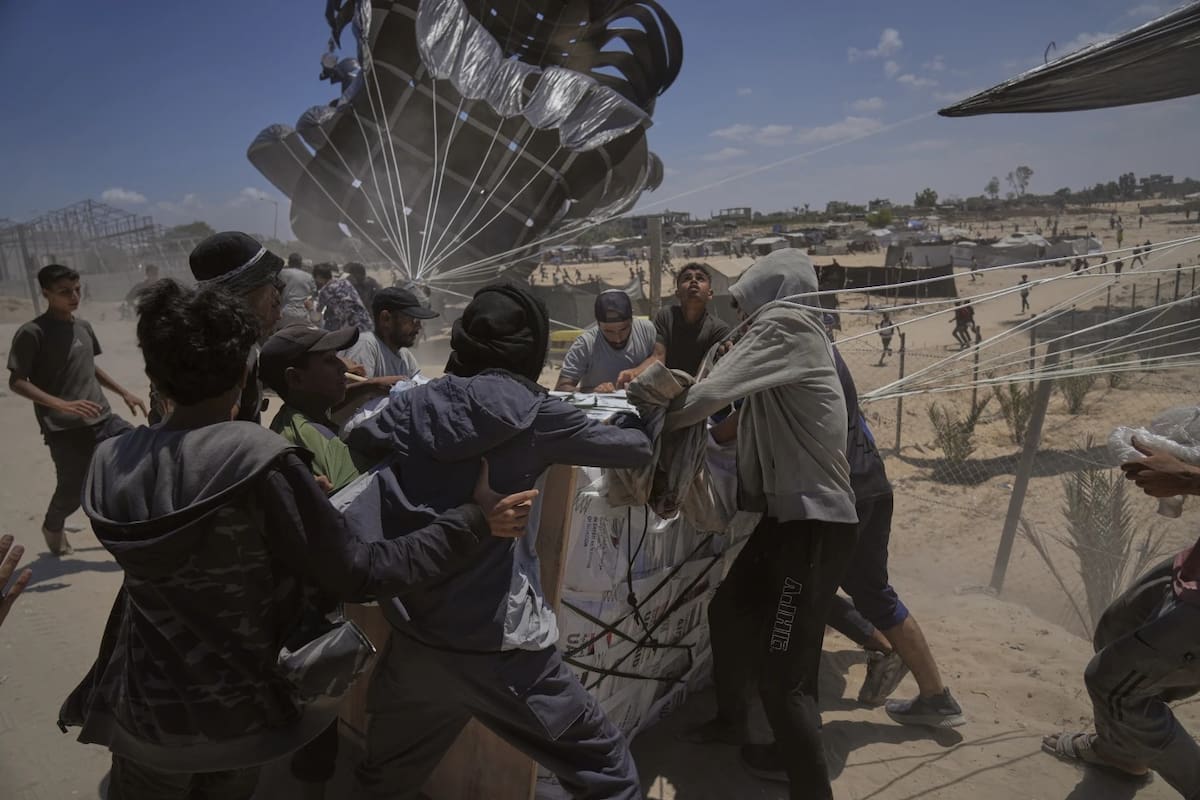 Palestinos se apresuran a recoger la ayuda humanitaria lanzada en paracaídas sobre Deir al-Balah, en el centro de la Franja de Gaza, el martes 5 de agosto de 2025. | Crédito: AP/Abdel Kareem Hana, archivo