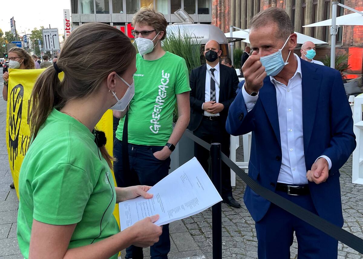 Fotografía de archivo donde aparece el presidente de la automotriz alemana Volkswagen AG, Herbert Diess, hablando con miembros de Greenpeace antes de entrar al salón del automóvil IAA 2021, en Múnich, Alemania. 5 de septiembre, 2021. | Crédito: REUTERS/Jan Schwartz