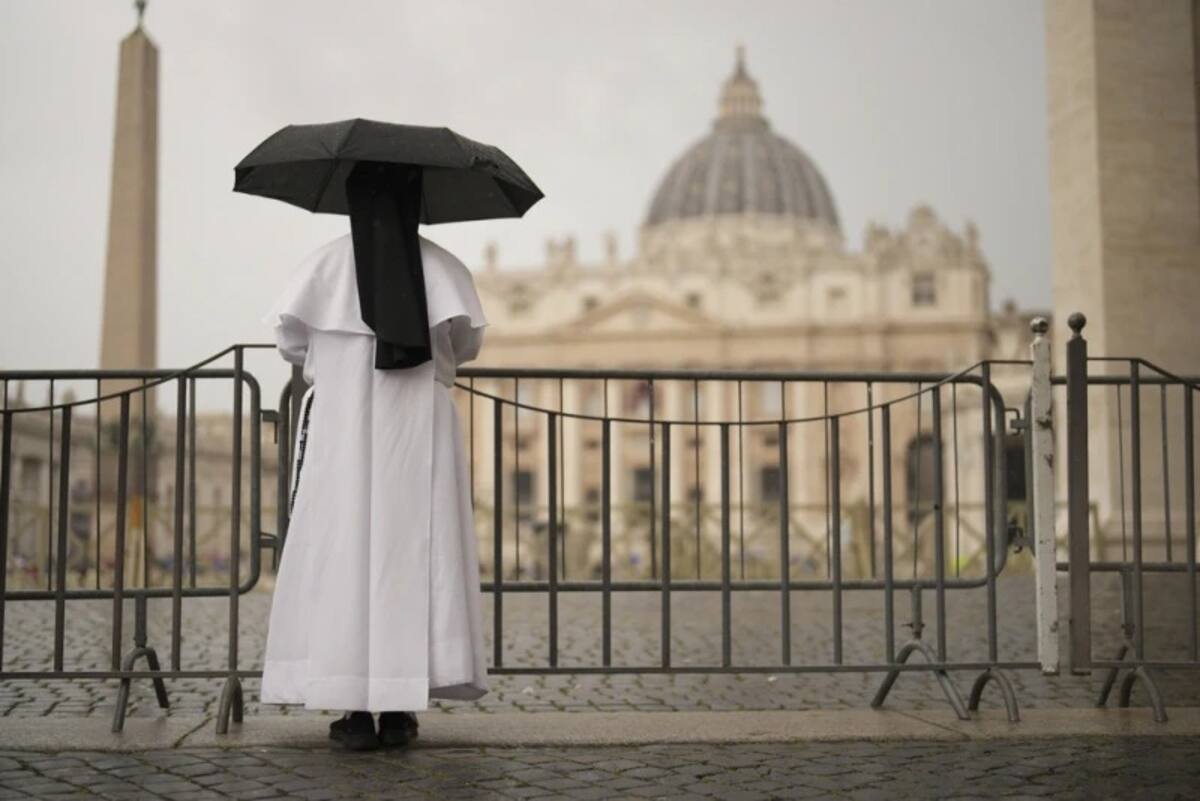 Una monja se resguarda de la lluvia tras la misa final celebrada por los cardenales en la Basílica de San Pedro, antes del cónclave para elegir al nuevo papa, en la Plaza de San Pedro, en el Vaticano, el miércoles 7 de mayo de 2025. | Crédito: AP/Francisco Seco