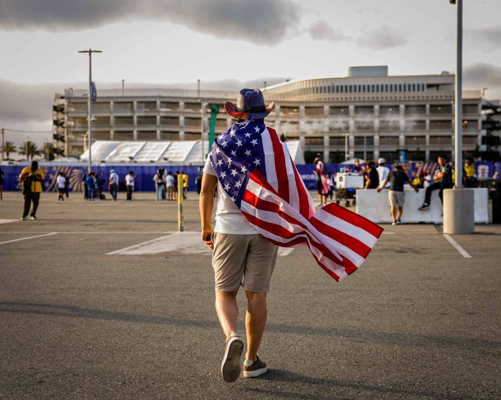 Un aficionado camina hacia el estadio donde se disputó el partido entre Estados Unidos y Paraguay en Los Ángeles, durante la Copa Mundial 2026. El seguidor porta una bandera estadounidense a manera de capa. (Foto: Javier Gallegos)