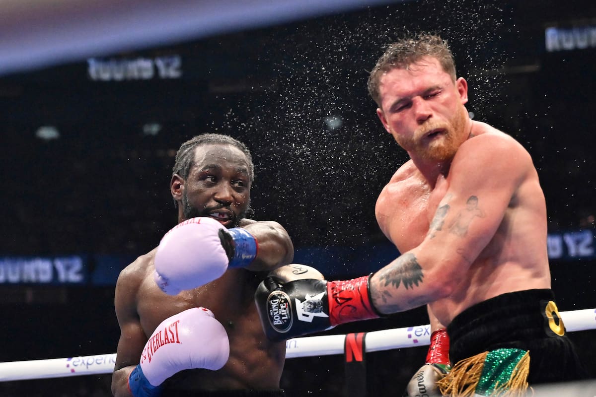Terence Crawford, left, punches Canelo Alvarez during an undisputed super middleweight championship boxing match in Las Vegas, Saturday, Sept. 13, 2025. (AP Photo/David Becker)