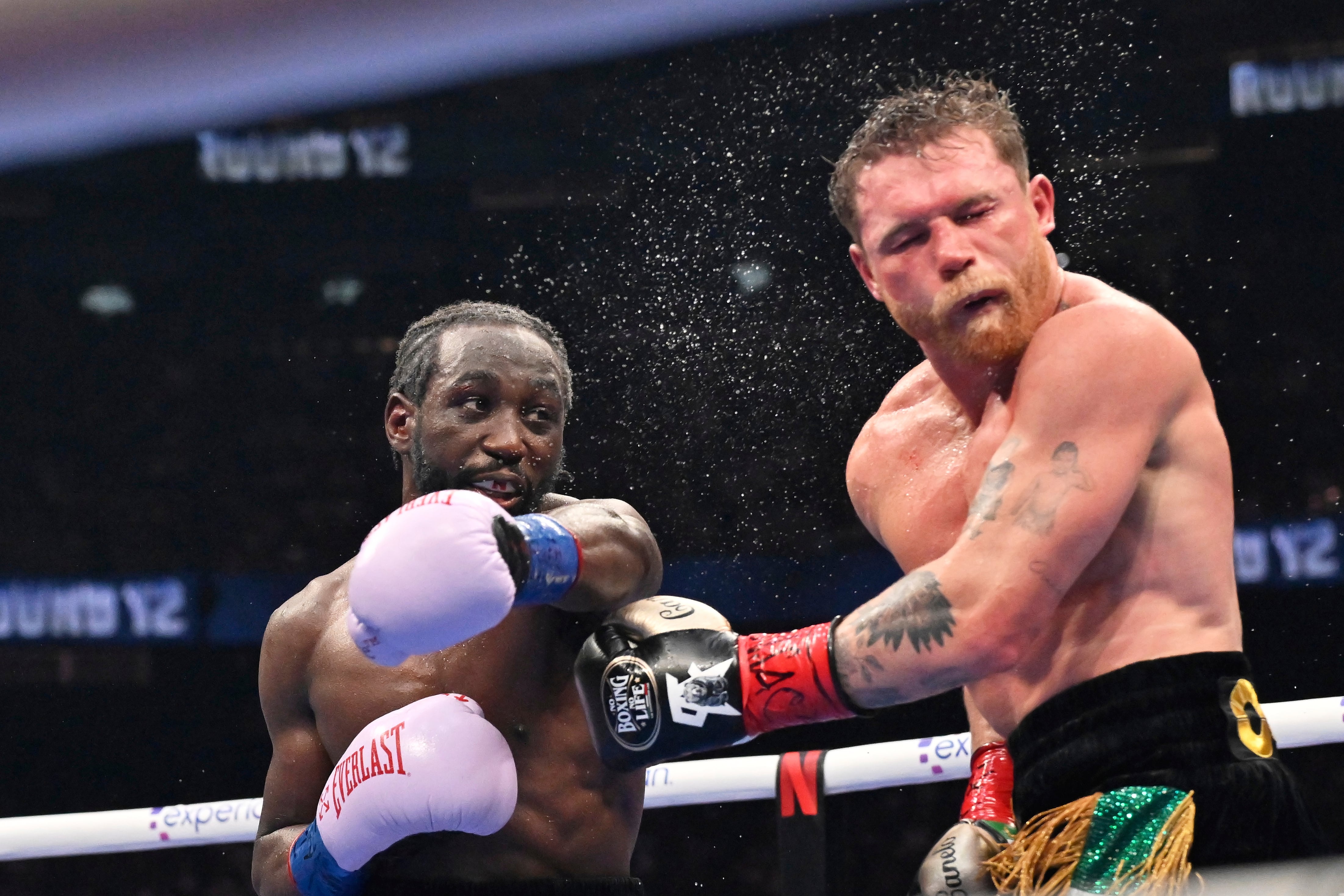 Terence Crawford, left, punches Canelo Alvarez during an undisputed super middleweight championship boxing match in Las Vegas, Saturday, Sept. 13, 2025. (AP Photo/David Becker)